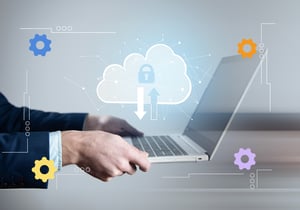 Hands holding an open laptop with icons of a cloud, lock, arrows, and gears.