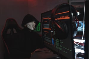 A hacker behind monitors.